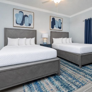 Tranquil guest bedroom featuring two queen beds, stylish decor, and soft lighting for a restful vibe