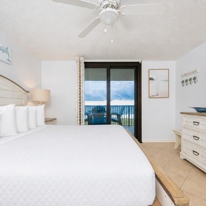 Sink into the plush king bed, enjoying coastal views through sliding doors that open to your balcony