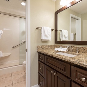 Refresh in this stylish master bath featuring a spacious vanity with granite countertops and a glass-enclosed walk-in shower