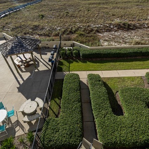 Outdoor area features a gazebo, lounge chairs, and a fun kiddie pool surrounded by manicured greenery and pathways