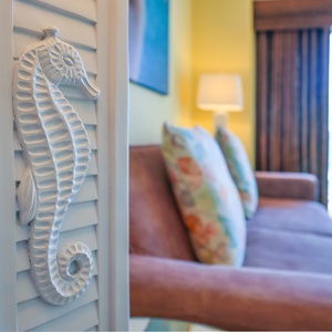 This inviting living area features a cozy pink sofa, colorful pillows, and a charming seahorse accent, perfect for relaxation