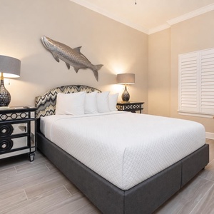 Relax on the soft queen bed and admire the large fish sculpture above the headboard in this guest suite