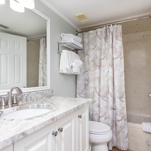 Master bathroom featuring a granite countertop, elegant shower curtain, and fresh towels for your comfort