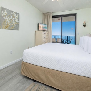 Relax in the comfortable master bedroom with a king bed, a TV, and easy access to a balcony offering beautiful views