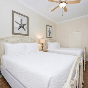 Relax in this guest bedroom featuring two queen beds, coastal decor, and a charming beach vibe