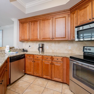 Kitchen featuring warm wood cabinetry, granite countertops, and stainless appliances, perfect for culinary adventures