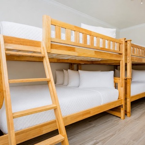 Cozy bunk room with two wooden bunks, each with two double beds for a restful retreat