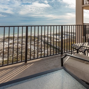 Relax on the balcony with comfortable seating and enjoy the tranquil view of the shoreline and gentle waves