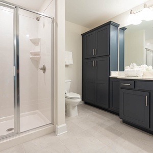 Enter the glass shower for a warm rinse, then dry off with plush towels in this guest bath