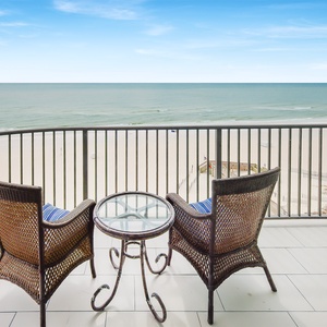 Enjoy your morning coffee on the balcony with cozy seating and lovely views of the beach and gentle waves