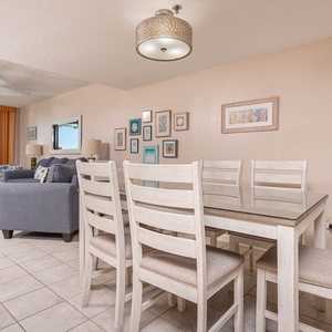 Inviting living area with coastal decor, featuring a cozy sofa and stunning views from the large windows