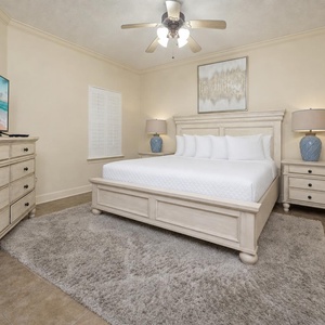 Serene master bedroom featuring a plush king bed, a large TV, and soft lighting for a restful retreat