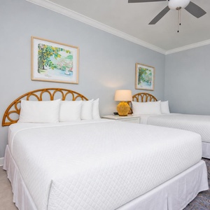 Unwind in this guest bedroom featuring two queen beds, vibrant decor, and soft lighting for a restful stay