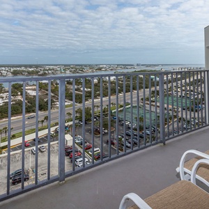 Master balcony view showcasing nearby greenery, roadways, and distant water, perfect for enjoying the coastal atmosphere