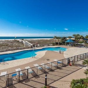 Enjoy the inviting pool area with lounge chairs, surrounded by lush landscaping and stunning views of the water