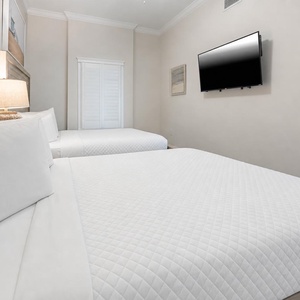 Relax on one of the cozy queen beds in this guest suite and stream your favorite shows after a beach day