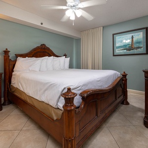 This cozy guest bedroom features elegant wooden furnishings, a large king bed, and a flat-screen TV for your entertainment