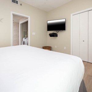 Relax in this guest bedroom featuring a king bed, a wall-mounted TV, and charming starfish decor