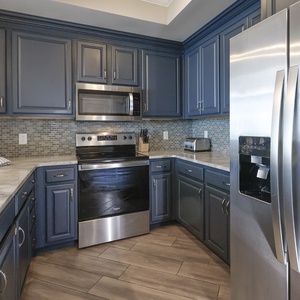 Prepare meals in this kitchen with elegant cabinetry, stainless appliances, and stylish backsplash