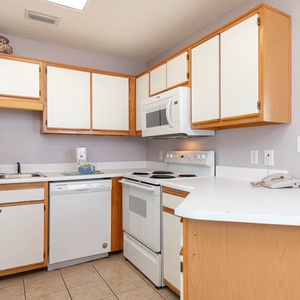 Kitchen features white cabinetry, a double sink, and a convenient layout, perfect for preparing meals during your stay