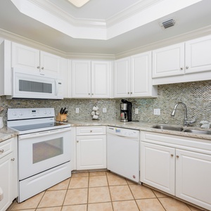 Whip up your favorite meals in this inviting kitchen, featuring ample counter space and a stylish backsplash