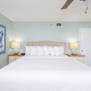 Retreat to this serene master bedroom featuring a king bed, coastal decor, and soft lighting for a restful stay