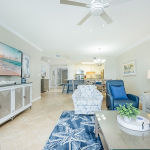 Unwind in the airy living area, featuring a large TV, sofa with full sleeper, and coastal decor for a relaxing retreat