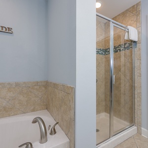 The master bath shower invites you to refresh after a day exploring the coast in warm earthy tones