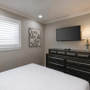 This cozy bedroom features a comfortable bed, a mounted TV, and stylish decor, perfect for relaxation after a day of fun