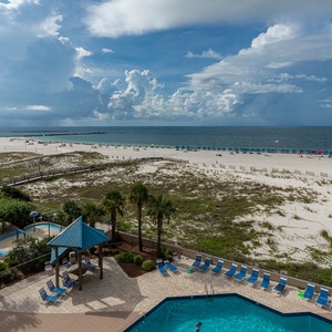 Take in the scenic view of the beach and pool area, perfect for relaxation and enjoying the coastal atmosphere