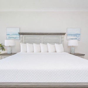 Inviting master suite featuring a king bed, soft pillows, and soothing coastal decor