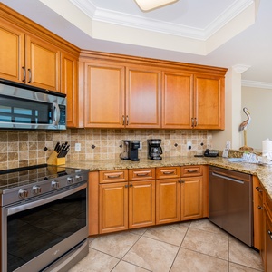 The kitchen features wood cabinetry, stainless appliances, and a convenient coffee maker for a delightful cooking experience