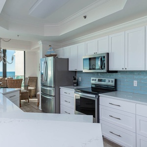 Prepare meals in the sleek kitchen with modern stainless steel appliances and a spacious countertop, perfect for gatherings