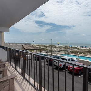 Enjoy a relaxing view from the balcony overlooking the pool and beach, perfect for unwinding after a day of fun