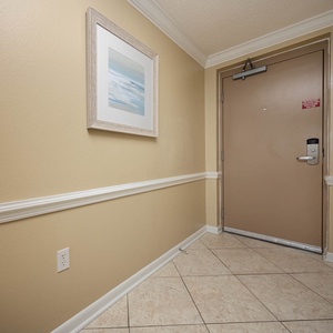Step into a welcoming entryway featuring tile flooring, soft lighting, and coastal artwork to set a relaxing tone