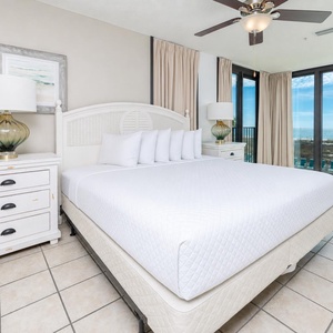 Relax in this inviting bedroom with a king bed and large windows offering a beautiful view of the outdoors