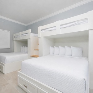Cozy bunk room with a stylish design featuring two queens below and two lofted twins above