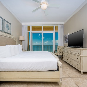 Serene master bedroom featuring a king bed, a TV, and beachfront balcony access