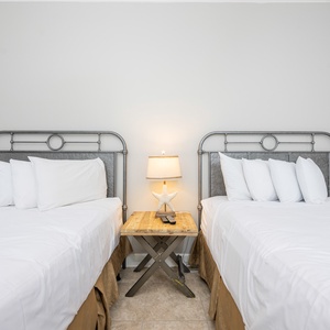 Inviting guest room with two queen beds and a charming bedside lamp for a relaxing vibe