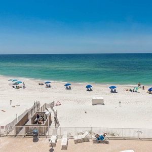 This inviting space offers a stunning beachfront view with colorful umbrellas dotting the sandy shore, perfect for relaxation