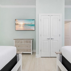 Serene guest bedroom featuring two comfortable queen beds and a TV for relaxing with your favorite show