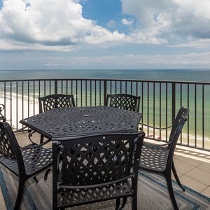 Enjoy meals or drinks on the balcony with a hexagonal table and chairs, offering stunning views of the coastline