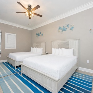Fun guest bedroom with two queens, blue accents, and playful turtle decor