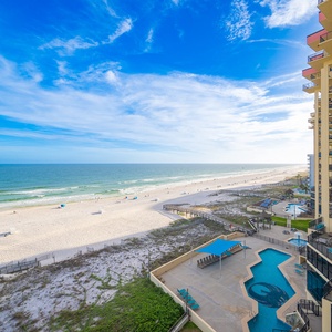 Endless blue horizon stretches beyond your balcony as you watch families enjoy the coast