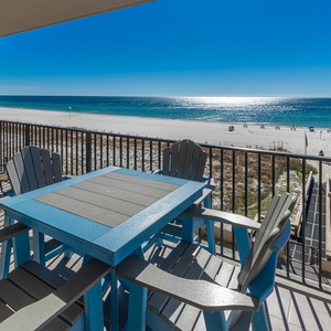 Savor meals at the blue table while enjoying breathtaking views of the tranquil water and nearby beach