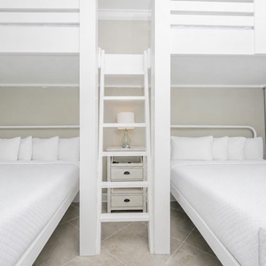 Wake up to a beautiful beach sunrise in this guest bunk room with two queens below and two lofted twins above