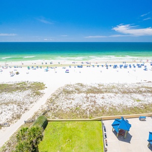 The view showcases a serene beach with soft white sand and calm waters, perfect for relaxation and seaside enjoyment