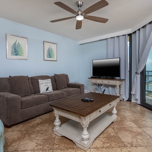 The inviting living area features a plush sofa with queen sleeper, a stylish coffee table, and a beach front view