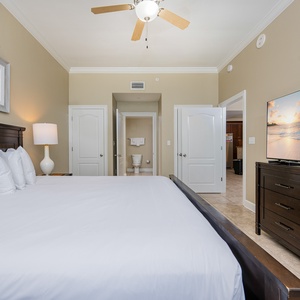 Unwind in the spacious master suite with a king bed, a large TV, and soft lighting that creates a relaxing vibe