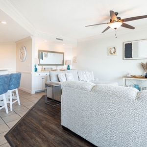 Feel the gentle breeze as you relax on the plush sofa, surrounded by coastal decor and inviting ambiance